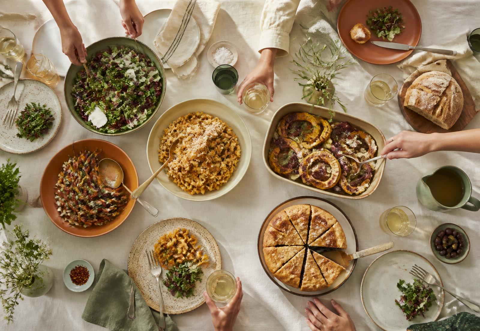 Overhead view of a potluck table covered with shared dishes